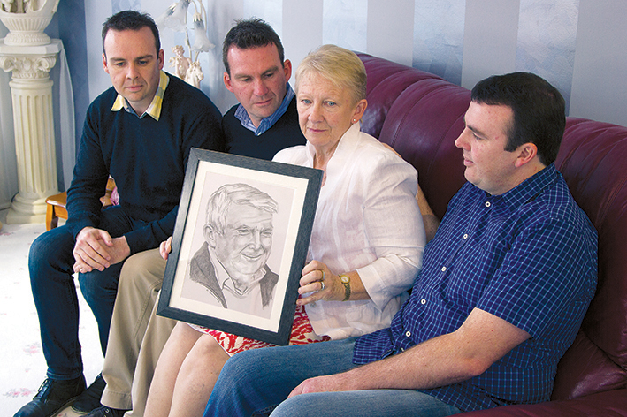 A shattered family: Dale, Christian, Bridget and Trent O’Toole with a drawing of Dermot that hangs in the family loungeroom. Picture: Cameron McCullough