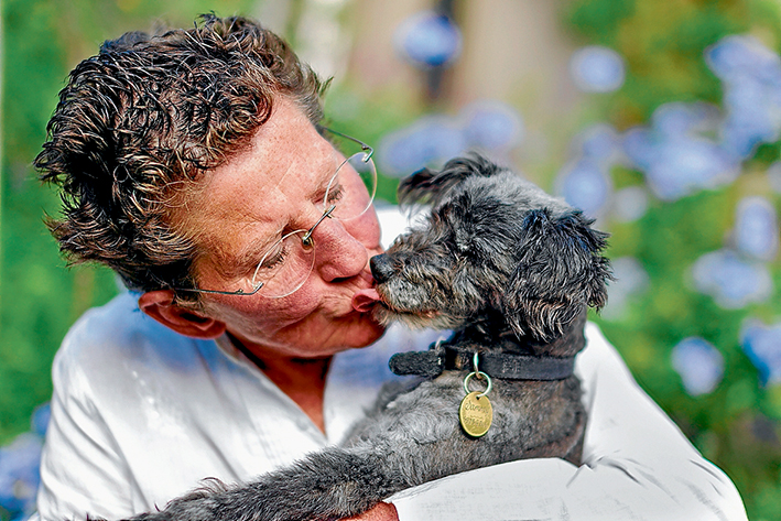 Loving cuddle: Owner Maggie Brown gives Sammy a hug after his ordeal. Picture: Yanni 