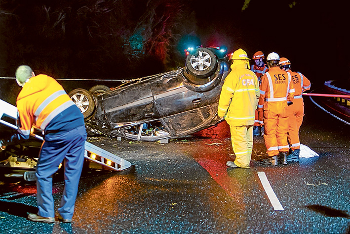 Crash scene: SES and CFA crews attempt to right the upturned car on Nepean Hwy before it is towed away. Picture: Gary Sissons
