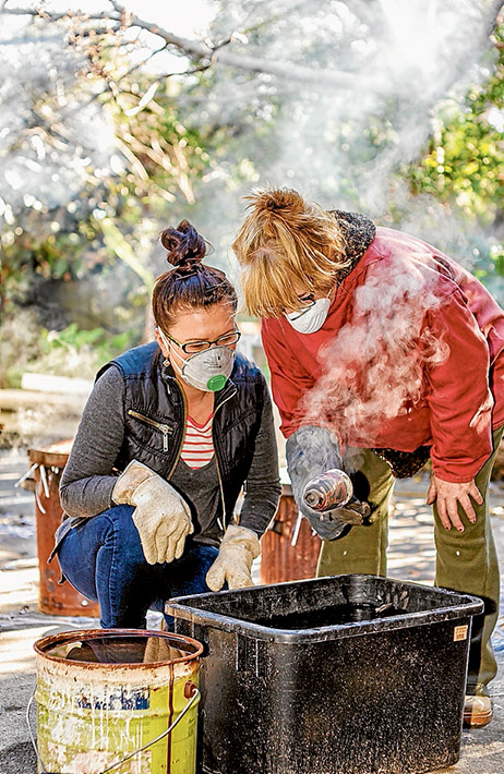 All fired up: Ceramicists Ev Burton, left, and Sue Sanderson practice the ancient art of raku at Rye. Picture: Yanni