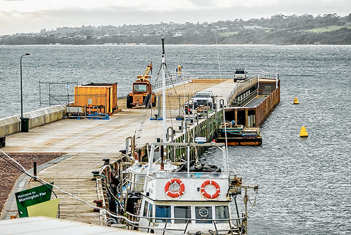 Not long now: Parks Victoria contractors put the finishing touches to the outer, 75-metre section of Mornington pier on Friday. Ports minister Luke Donnellan is this week expected to announce the opening date, weather permitting. Picture: Yanni