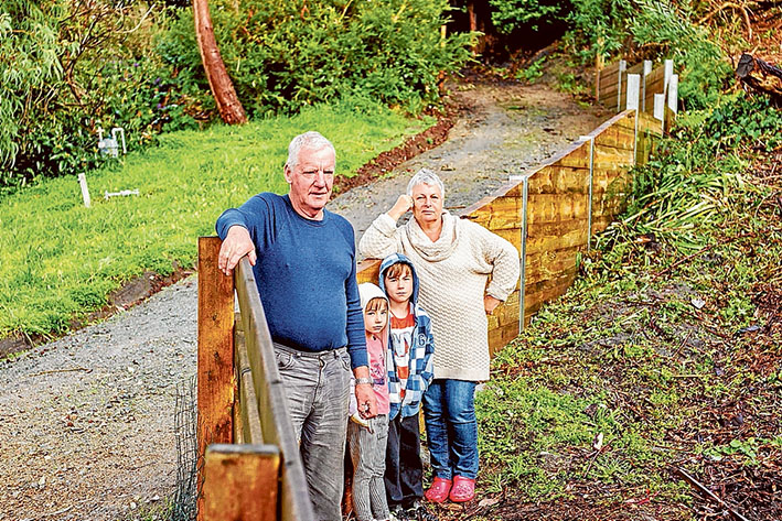 Clear way: John and Carol Van Der Helm and grandchildren Jayden and Imogen and the wall they say should go. Picture: Yanni