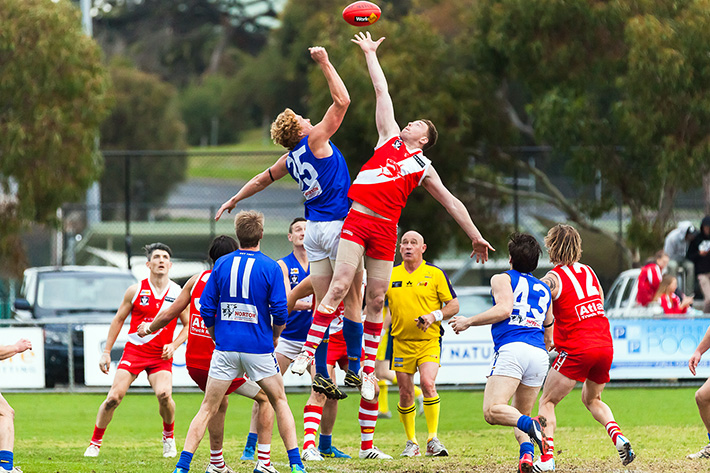 Eyes on the pill: Sorrento got up over Hastings in Saturday’s Nepean League clash, left, with a final quarter eight-goal burst enough to see the Sharks over the line against the Blues. Picture: Andrew Hurst