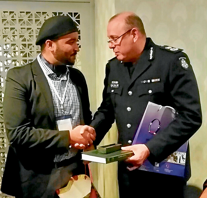 Police present: Imam Janud of the Ahmadiyya Muslim Association Victoria mosque at Langwarrin presents a copy of the Koran to Chief Commissioner Graham Ashton.