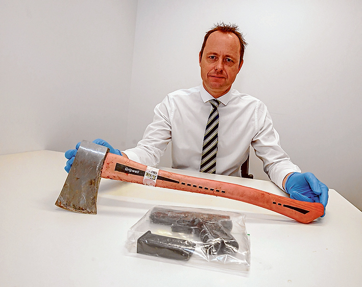 Weapons query: Detective Al Hanson, of Frankston Embona Armed Robbery Task Force, displays the axe and a handgun allegedly used in the 7-Eleven robberies.