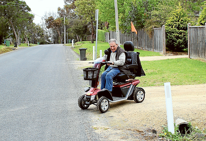 Footpath needed: Somers resident Doug Coates says a made footpath in the village cannot come soon enough. A Somers resident for 33 years, Mr Coates has to use the road to get from his house to anywhere in Somers on his mobility scooter. He says he cannot drive over the nature strips, despite buying a larger scooter with wider wheels, and is forced onto the road, competing with cars and buses.