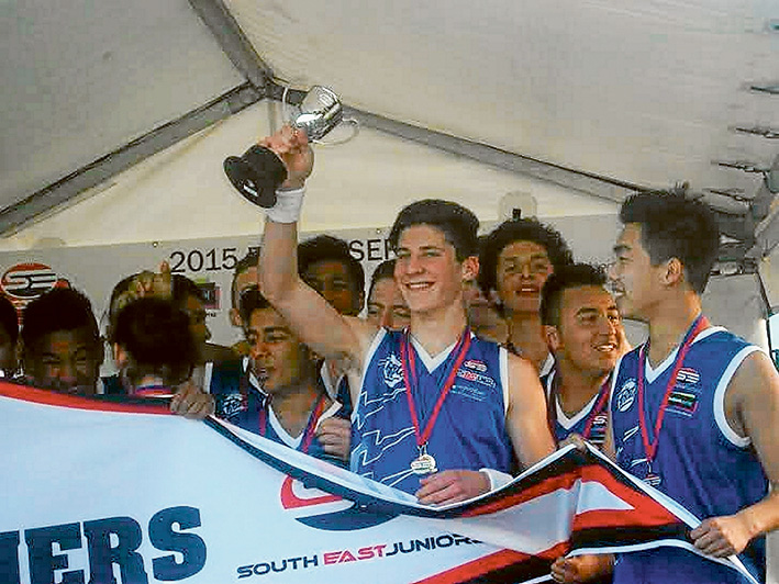 It’s ours: Perry Lewis-Smith celebrates his football premiership win with team mates.
