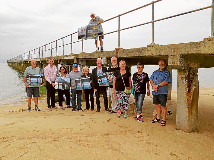 Group pressure: Save Dromana Pier supporters show their reasons for campaign for a new pier while standing next to a crumbling pylon.
