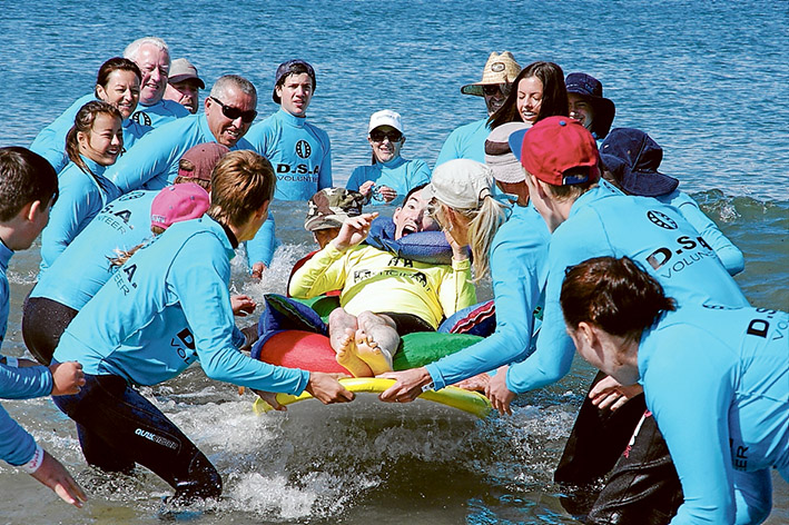 Team effort: Many hands are involved during surfing for the disabled events at Point Leo, but non wave more than the delighted board riders. Picture: Keith Platt