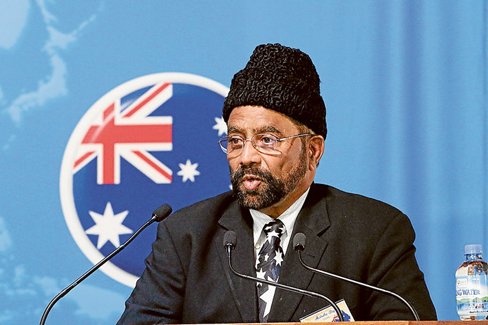 Loyal children: Imam Inamul Haq Kauser, above, says children of Ahmadi Muslims will be Australia’s “best citizens”; children at the Baitu-us-Salam (House of Peace) Mosque, Langwarrin, sing the national anthem during an Australia Day dinner, below. Pictures: Supplied