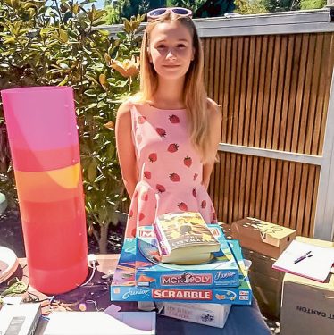 Out they go: Lily Ford mans the stall, with funds raised to help her former teacher’s special charity.