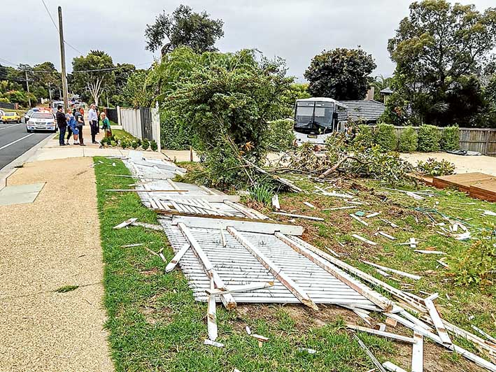 Rear window: Amazed neighbours count the cost as SES volunteers and police work to extricate the bus from their Mt Eliza properties. The bus’s backward route down Humphries Rd, Mt Eliza, left smashed fences and shrubs in its wake before nearly nearly destroying a studio. Pictures: Gary Sissons