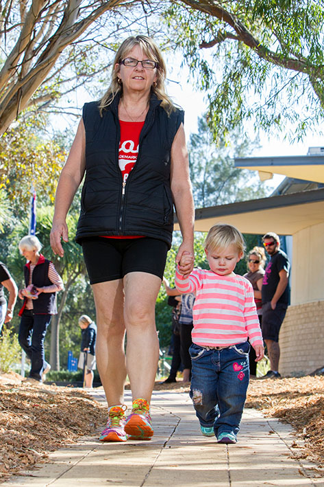 Look mum: Susanne Parkinson and granddaughter Macey Cole, 21 months, above, walk the memorial path at Crib Point Primary School watched by proud mum Natalie, rear, of Crib Point, who is just out of hospital with her four-day-old baby on its first outing. Picture: Gary Sissons