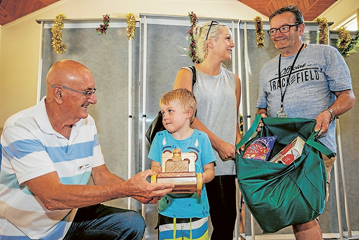 Season’s cheer: Mike O’Grady and Chris Grundy hand out Christmas hampers to Abbey Beckworth and Blake Cross. Picture: Yanni