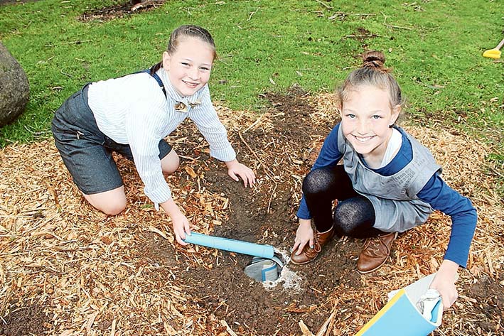 In costume: Pupils Chelsea Thompson and Abbi Andrew, both 11, unearth the 25-year-old time capsule at Bittern Primary School’s 100th birthday.