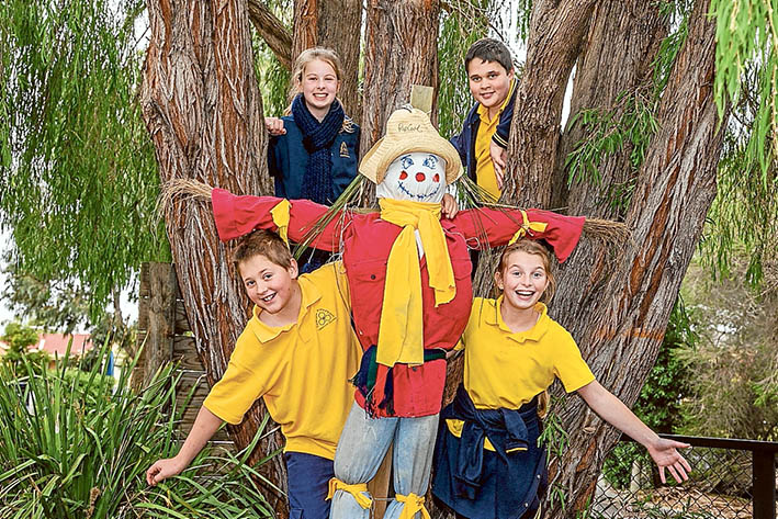 Class act: Artist Michael Leeworthy treated Eastbourne Primary School pupils to a morning of making scarecrows. Here, Jazmyn and Shaun (rear) and Bruce and Sophie show off their creation.         Picture: Gary Sissons