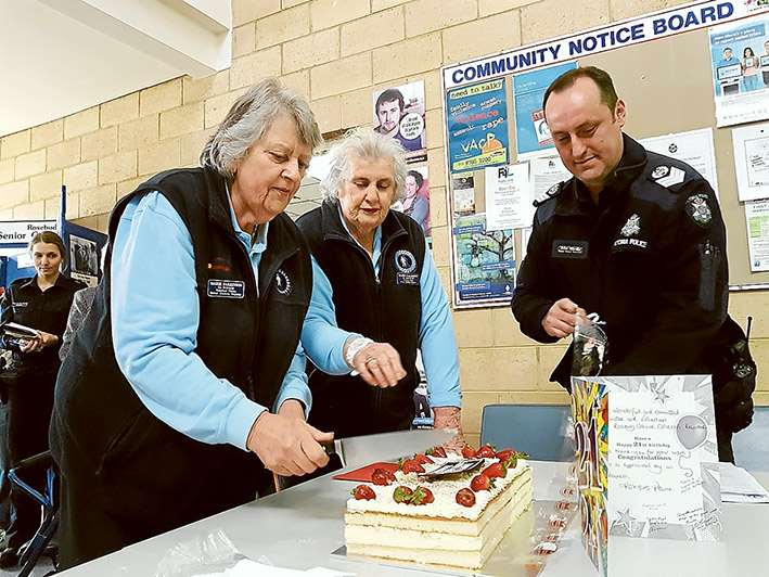 Milestone: Rosebud Police Senior Citizens Register Co-ordinators Marie Parkinson and Elaine Wallbridge cut the 21st birthday cake with Senior Sergeant John Wardle.