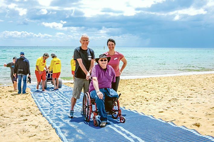 Available to all: Bill Hallett and Virginia Richardson show Mark Hopper how to best use the wheelchair-friendly plastic matting being trialled by Mt Martha Life Saving Club.